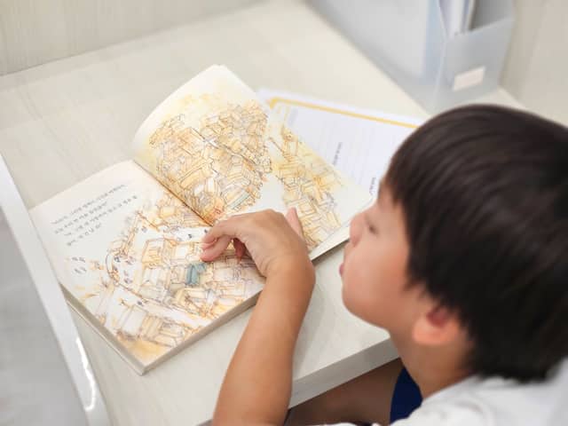 학생이 그림책을 읽으며 내용을 따라가는 모습